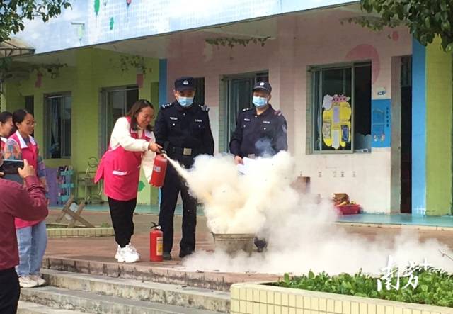 公安民警變身“消防安全老師”，指導(dǎo)幼兒園老師使用滅火器。