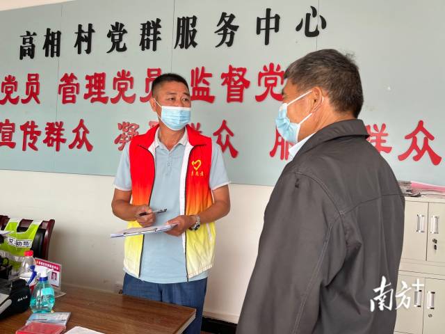 正在為群眾辦事的沈家江（左）。