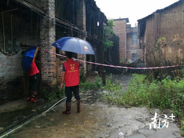 黨群志愿者冒雨拉起警戒線。